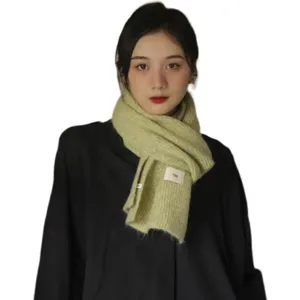 Detailed view of the ultra-soft fluffy knitted scarf with cloth label, warm and cozy winter accessory.