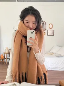 Thick mohair winter scarf detail view, cozy knitted tassel design in solid camel color.