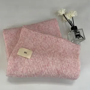 Soft thick knit pink winter scarf detail view with cute woven label and cozy texture