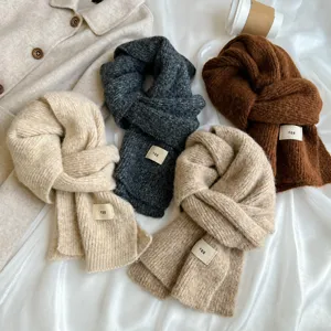Detailed view of thick knitted winter scarf featuring soft texture and cozy solid colors.