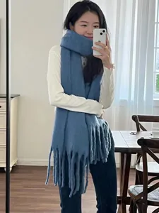 Detailed view of cozy blue mohair tassel scarf, soft winter knit texture for cold weather wear.