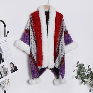 Ethnic style knit cape with faux fur collar and pom-poms, cozy winter travel shawl for women.