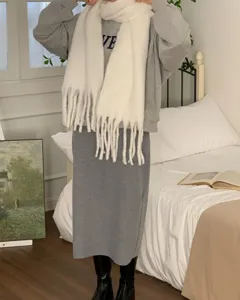 Cozy mohair winter scarf detailed look, white knitted fringe scarf in a warm bedroom style.