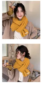 Detailed view of yellow knitted winter scarf with woven label, cozy neck warmer closeup.
