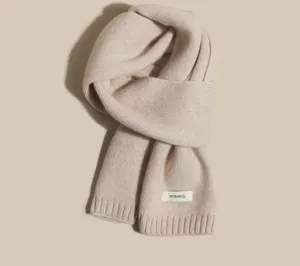 Detailed view of soft beige knitted wool scarf, classic winter warm neck accessory for women.