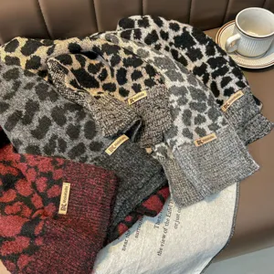 Vista dettagliata della comoda sciarpa lavorata a maglia leopardata, morbida e calda.