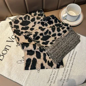 Dettaglio della sciarpa in maglia con stampa leopardata e consistenza morbida.