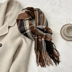 Detailed view of the brown plaid imitation cashmere scarf with soft tassels and cozy winter style.