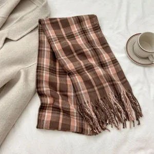 Close-up detail of autumn winter brown plaid imitation cashmere scarf with soft tassels.
