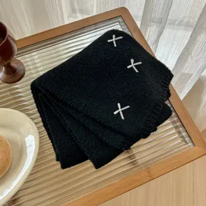 Black knitted scarf detail shot with white bow embroidery cozy winter warm accessory
