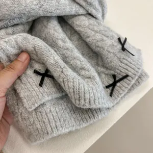 Grey knit scarf detail, cute black bow accent, winter warm neck accessory close-up