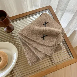 Detailed view of the cozy wool blend knitted neckerchief featuring cute black ribbon accents.