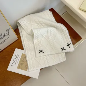 Cozy white knit winter scarf for women, featuring black bow accents, soft thick warm neck wrap.