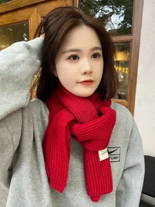 Detailed view of women's cozy winter knit scarf in stylish red, warm and soft fashion accessory.