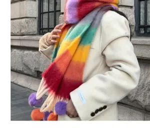 Rainbow mohair winter scarf with fluffy pom poms and cozy tassels, detailed view of texture.