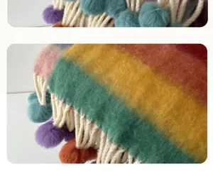 Detailed view of a cozy rainbow mohair scarf featuring playful pom-pom tassels and soft texture.