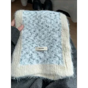 Cozy winter knitted scarf with contrast color trim and woven label for women daily wear.