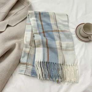 Blue and white plaid imitation cashmere scarf detail showing soft fringe and cozy winter texture.