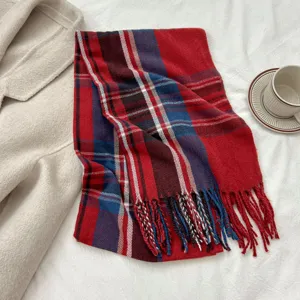 Detailed view of winter classic red plaid cashmere-like warm scarf with fringe hem.