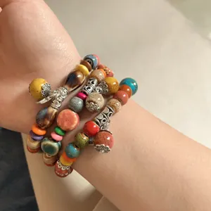 Vista detallada de la pulsera de cuentas de cerámica y madera étnica colorida.
