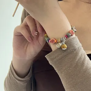 Pulsera de cuentas de cerámica y madera étnica, vista detallada que muestra diseño y dijes.
