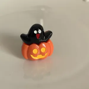 Close-up detail showcasing the quirky Halloween pumpkin ghost ring, unique cute accessory.