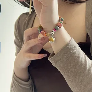 Primer plano detallado de pulsera de cuentas de cerámica y madera de estilo étnico en muñeca.