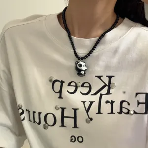 Vista detallada de un elegante collar de cuentas negras con un lindo colgante de calavera.