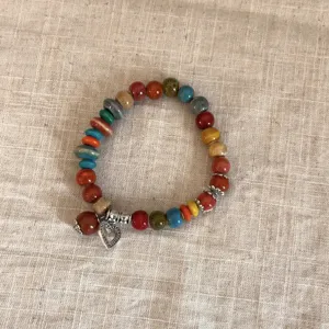 Pulsera de cuentas de cerámica y madera estilo étnico vintage con dije de corazón, vista detallada.