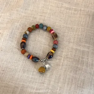 Vista detallada de la pulsera de cuentas de cerámica étnica, accesorios colgantes coloridos.