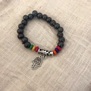 Pulsera de cuentas étnica bohemia con cuentas de cerámica oscuras, detalles de madera y abalorio.