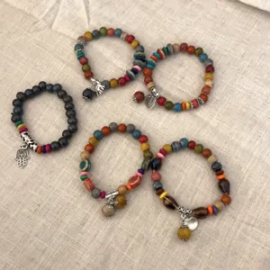 Juego de pulseras de cuentas de cerámica y madera étnica con bonitos dijes de metal para dama.