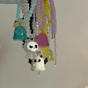 Detalle de collares de cuentas de fantasma de Halloween, joyería con dijes coloridos.