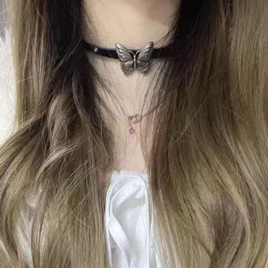 Close-up detail of Y2K punk style black leather butterfly choker necklace with metal pendant.