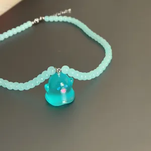 Primer plano del collar de cuentas azul claro con un bonito colgante fantasma de resina.