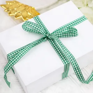 Dettaglio scatola regalo con nastro a quadretti verde, ideale per fai da te e confezioni.