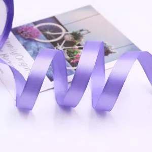 Detail view of a vibrant purple satin ribbon, neatly unrolled for elegant gift wrapping.