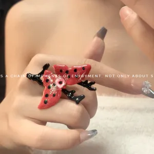 Anello a farfalla rosso e nero Y2K con occhio di vetro, indossato, vista principale.