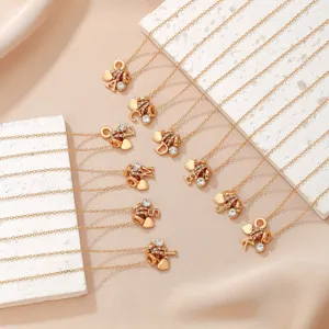 Gold-tone rhinestone alphabet letter pendant necklaces displayed on elegant white blocks.