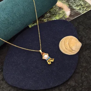Collier princesse de conte de fées avec zircons colorés et pendentif perle sur chaîne dorée.
