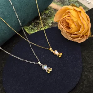 Gros plan détaillé de colliers pendentifs princesse de conte de fées en or et argent aux zircons.