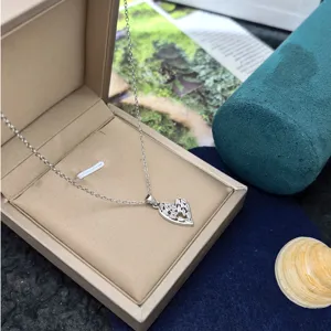Detailed shot of a delicate silver heart pendant necklace with shimmering baguette stones.