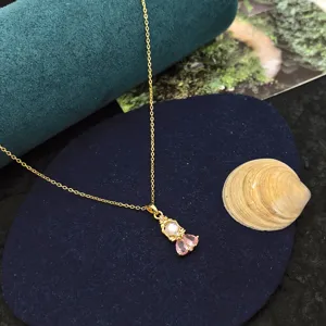 Collier pendentif princesse, chaîne dorée délicate avec zircone rose pour un style doux.