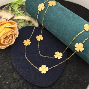 Gold four leaf clover long necklace detail view, luxury designer style fashion jewelry piece.