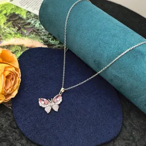 Stainless steel butterfly pendant necklace detail shot, sparkling pink zircon crystal stone.