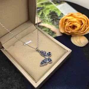 Close-up detail of the elegant hollow butterfly pendant necklace featuring blue and white crystal stones.
