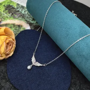 Close-up detail of the butterfly crystal and pearl necklace pendant on velvet display prop.