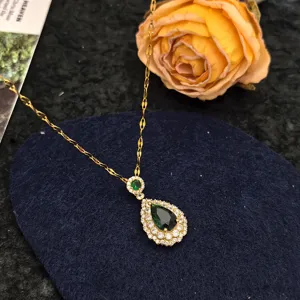 Emerald teardrop pendant necklace with sparkling zircon halo, elegant gold chain jewelry.