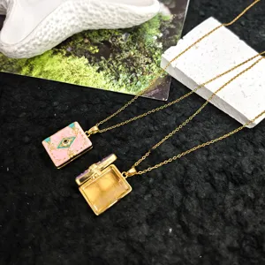 Close-up detail of cute pink book pendant necklace, showcasing open locket and enamel finish.