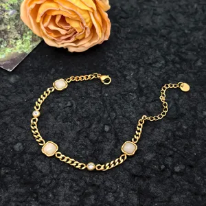 Gold-tone titanium steel chain detail featuring square white stones and sparkling round crystals.
